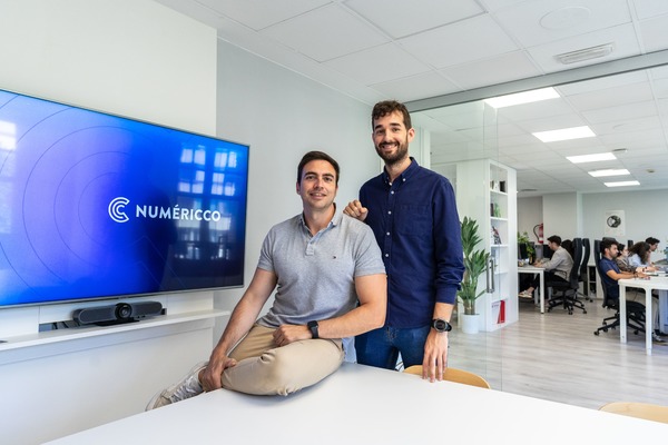 Los fundadores de Numéricco posan en una mesa de su oficina en Zaragoza